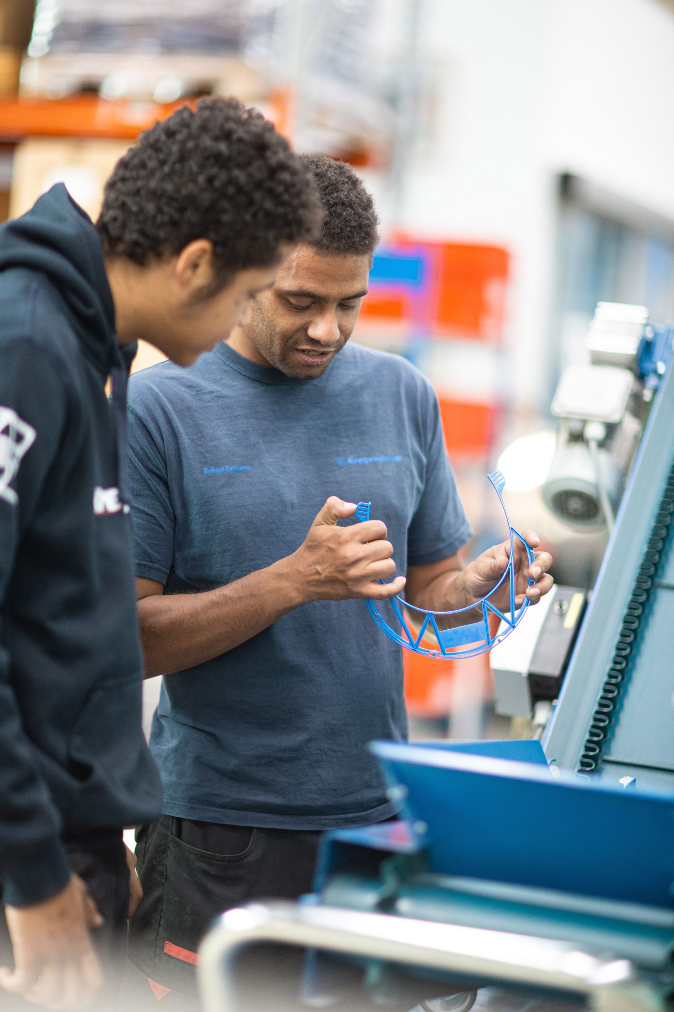 2 Mitarbeiter prüfen ein Werkstück in der CNC-Fertigung.